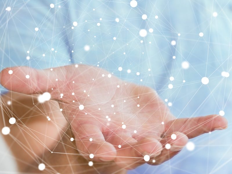 Businessman on blurred background holding flying network sphere 3D rendering